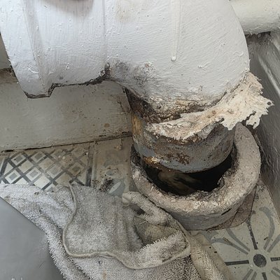 Poorly fitted toilet waste pipework before repair